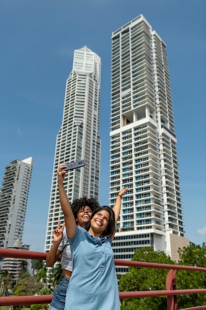 Retrato de duas amigas latinas tomando selfie na cidade do panamá, panamá