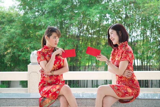 Retrato de duas belas mulheres asiáticas no vestido cheongsam, povo da tailândia, conceito de feliz ano novo chinês