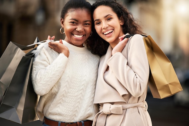 Retrato de duas jovens fazendo compras em um ambiente urbano