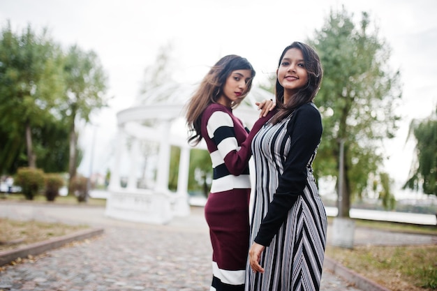 Retrato de duas jovens lindas adolescentes indianas ou sul-asiáticas em arco de templo branco de fundo de vestido