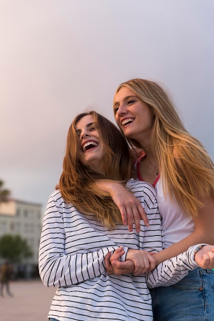 Foto retrato de duas jovens mulheres rindo