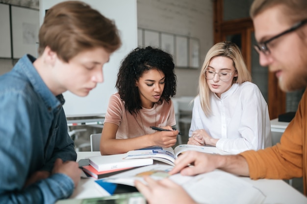 Retrato de duas lindas meninas trabalhando juntas enquanto estão sentadas à mesa na platéia