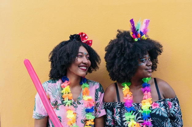 Retrato de duas mulheres afro celebrando o carnaval de rua