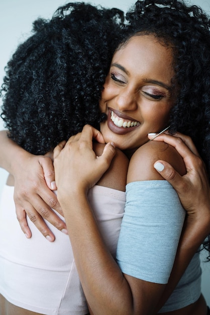 Foto retrato de duas mulheres de cor abraçadas