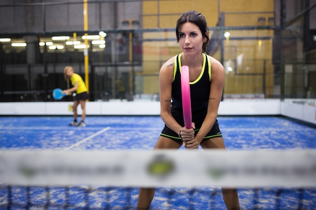 Retrato de duas mulheres jogando paddle.