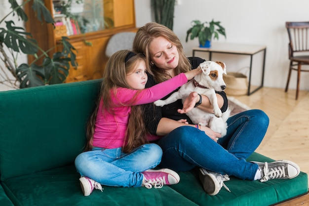 Foto retrato de duas pessoas amáveis, mãe e filho se abraçando, passarem o tempo juntos, sentados em um sofá confortável