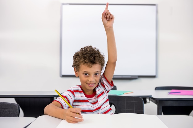 Foto retrato, de, elementar, menino, levantando mão, em, sala aula