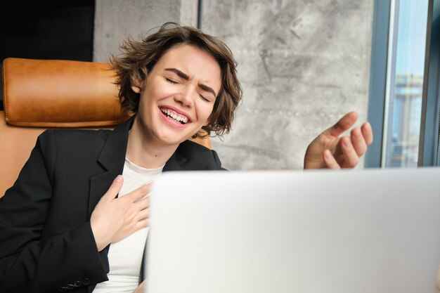 Foto retrato de empresária rindo se conecta a reuniões on-line ou bate-papo conversando e rindo sentado