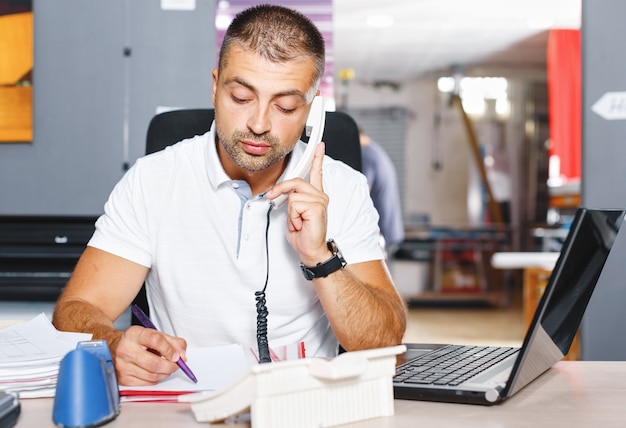 Retrato de empresário bem-sucedido trabalhando em um escritório movimentado