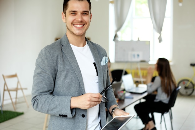 Retrato de empresário confiante e sorridente bonito no escritório