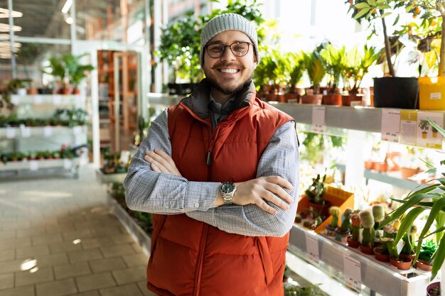 Retrato de empresário de jardineiro em flor e planta em vaso com sorriso no rosto