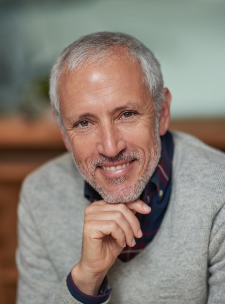 Retrato de empresário e sorriso no local de trabalho para compromisso de carreira e gerenciamento com orgulho Rosto de CEO e pessoa masculina corporativa no escritório para desenvolvimento de startups e projeto internacional