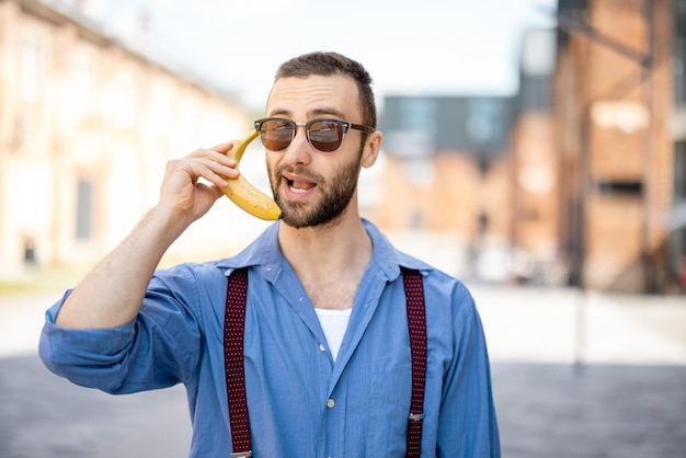 Retrato de empresário elegante estranho com banana ao ar livre