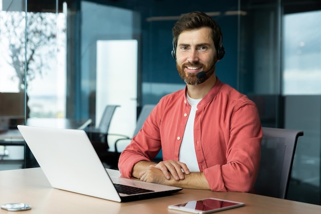 Retrato de empresário maduro em camisa vermelha dentro do escritório homem com barba e fone de ouvido de chamada de vídeo