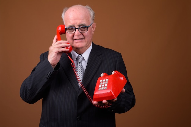 Retrato de empresário sênior com excesso de peso falando ao telefone
