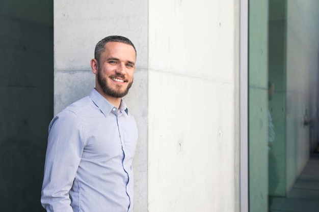 Retrato de empresário sorridente em uma parede