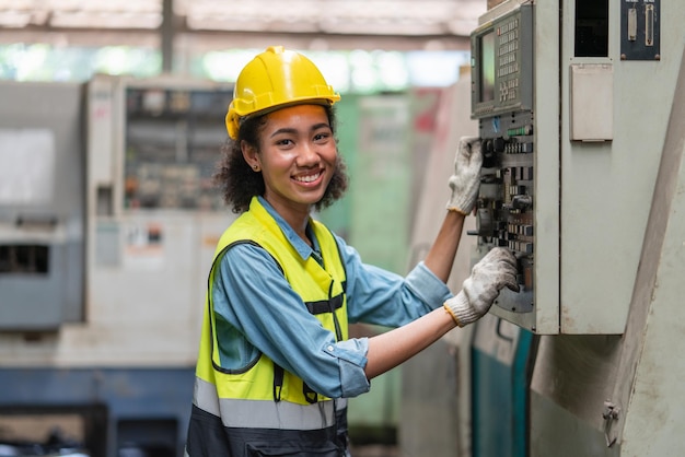 Retrato de engenheira em colete de segurança com capacete amarelo sorrindo para trabalhar na fábrica