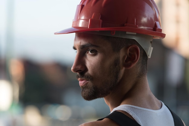 Retrato de engenheiro arquiteto masculino bonito com capacete vermelho