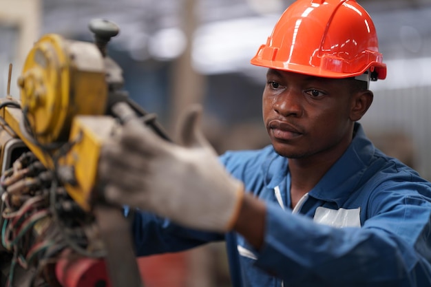 Retrato de engenheiro de indústria pesada profissional/trabalhador vestindo uniforme de segurança, óculos de proteção e capacete. Em segundo plano Grande Fábrica Industrial Desfocada