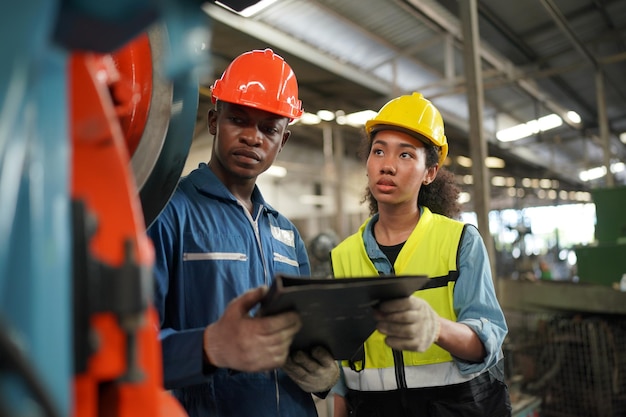 Retrato de engenheiro de indústria pesada profissional/trabalhador vestindo uniforme de segurança, óculos de proteção e capacete. em segundo plano grande fábrica industrial desfocada