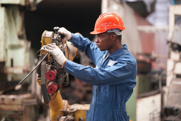 Retrato de engenheiro de indústria pesada profissional/trabalhador vestindo uniforme de segurança, óculos de proteção e capacete. Em segundo plano Grande Fábrica Industrial Desfocada