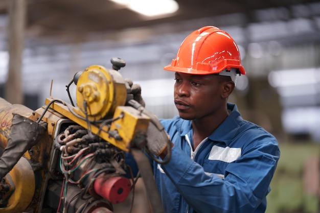 Retrato de engenheiro de indústria pesada profissional/trabalhador vestindo uniforme de segurança, óculos de proteção e capacete. Em segundo plano Grande Fábrica Industrial Desfocada