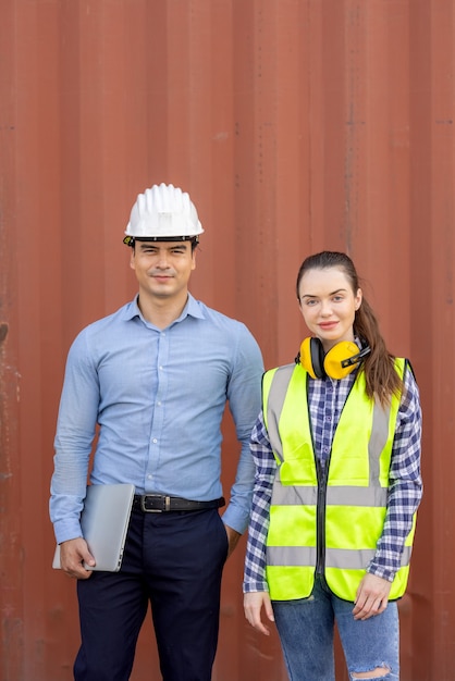 retrato de engenheiros confiantes em uniformes em frente aos contêineres.