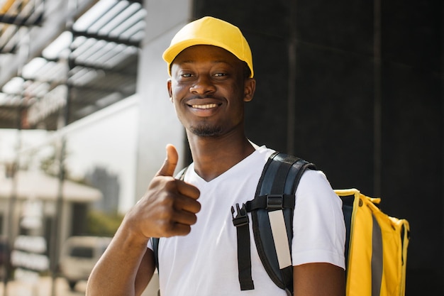 Retrato de entrega de comida de correio africano com mochila amarela e boné