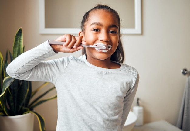 Retrato de escova de dentes de menina e escova de dentes para higiene com boca limpa e hálito fresco com saúde bucal Garoto limpando com pasta de dente no banheiro e bem-estar em casa de família com gengivas saudáveis