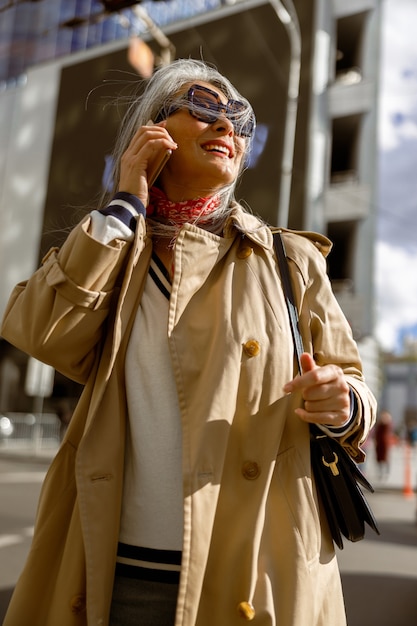 Retrato de estilo de vida de mulher elegante de cabelos claros maduros ao ar livre na cidade