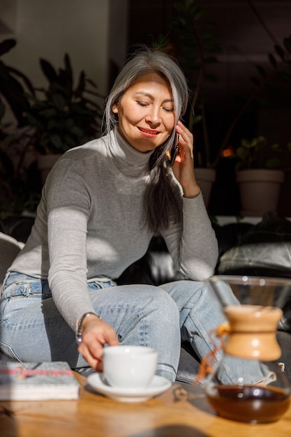 Retrato de estilo de vida de mulher elegante de cabelos claros maduros em café