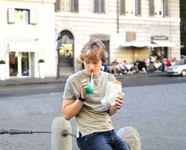 Retrato de estilo de vida de um jovem relaxando e almoçando