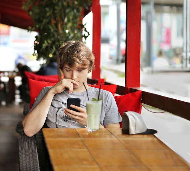 Retrato de estilo de vida de um jovem usando um smartphone ao ar livre