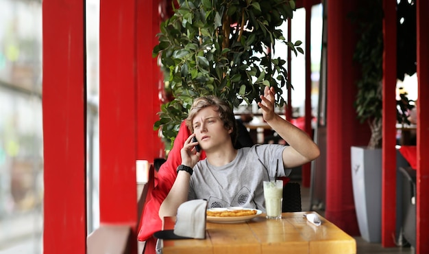 Retrato de estilo de vida de um jovem usando um smartphone ao ar livre