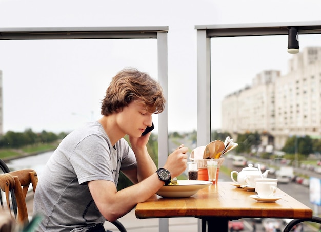 Retrato de estilo de vida de um jovem usando um smartphone ao ar livre