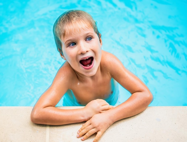 Retrato de estilo de vida engraçado Travesso cabelo loiro molhado sardento menino de olhos azuis boca aberta olhar surpresa jogar rindo na piscina Infância feliz esporte educação treinamento lição comportamento