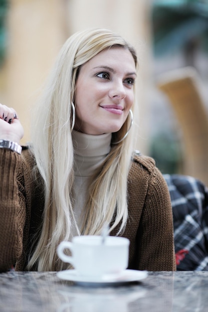 Retrato de estudante linda jovem enquanto relaxa na pausa para o café