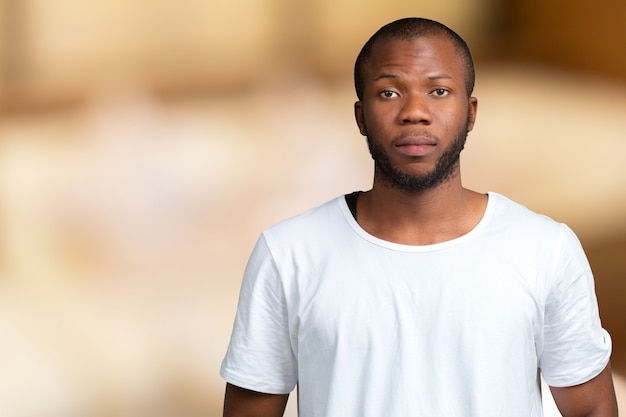 Retrato de estudante masculino africano stong e bonito, olhando para a câmera sorrindo