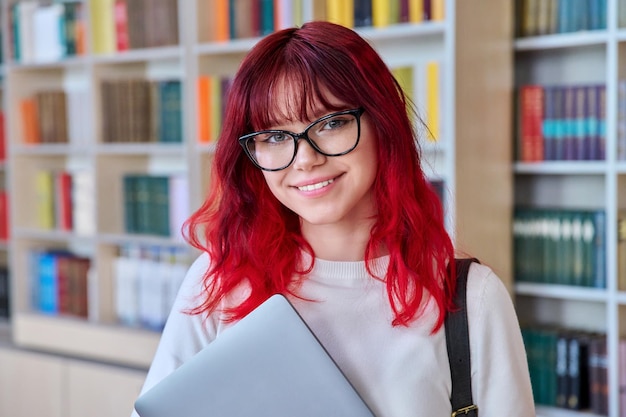 Retrato de estudante universitária em óculos com mochila para laptop olhando para a câmera