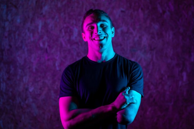 Foto retrato de estúdio com luzes de néon coloridas de um homem esportivo deficiente