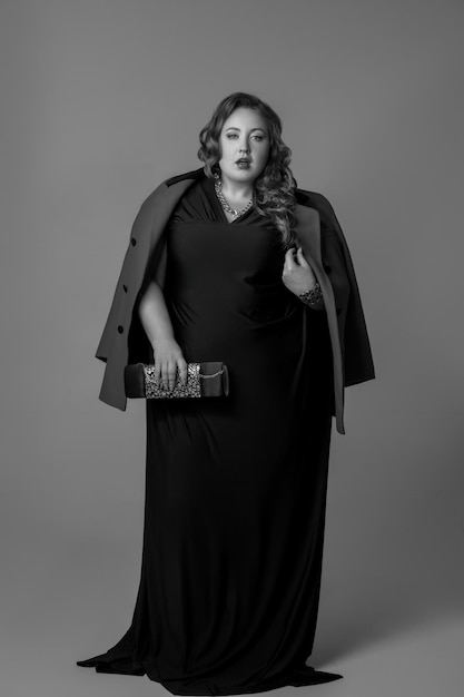 Retrato de estúdio de corpo inteiro de mulher em vestido longo posando. fotografia preto e branco