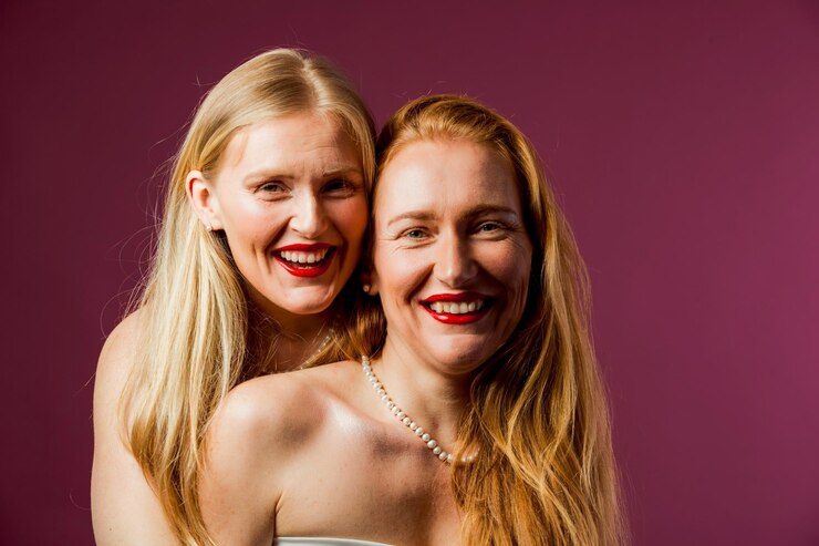 Foto retrato de estúdio de duas mulheres atraentes irmãs com cabelos longos saudáveis vestindo camisas brancas e batom vermelho brilhante senhoras sensuais em fundo roxo