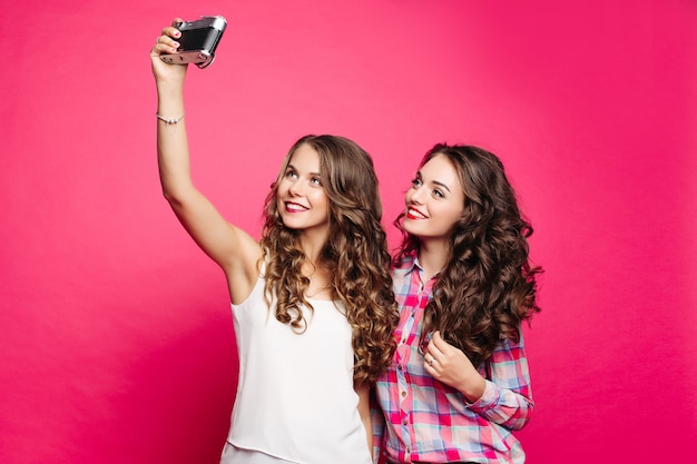 Retrato de estúdio de felizes meninas bonitas em estilo retro, com cabelo longo ondulado.