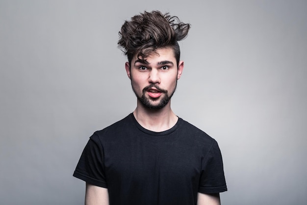 Retrato de estúdio de jovem bonito com penteado de moda