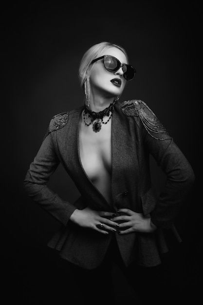 Retrato de estúdio de moda de uma mulher loira glamourosa usando óculos escuros e jaqueta