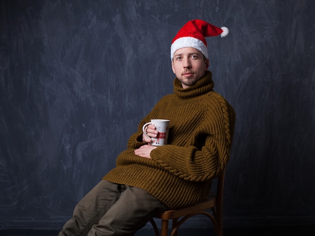 Retrato de estúdio de Natal de um cara barbudo em um boné vermelho