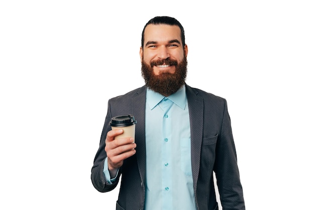 Retrato de estúdio de um homem barbudo segurando seu café favorito para viagem