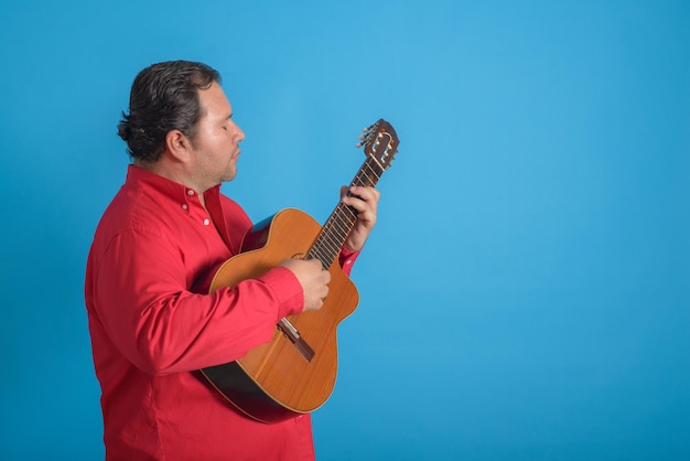 Retrato de estúdio de um homem tocando um velho tres cubano