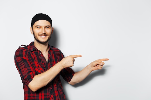 Retrato de estúdio de um jovem sorridente apontando para a esquerda Copie a ideia de espaço