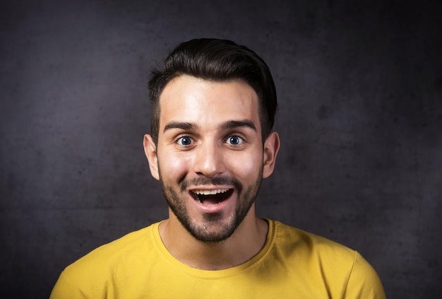 Retrato de estúdio de um jovem sorridente, olhando para o fundo cinza da câmera